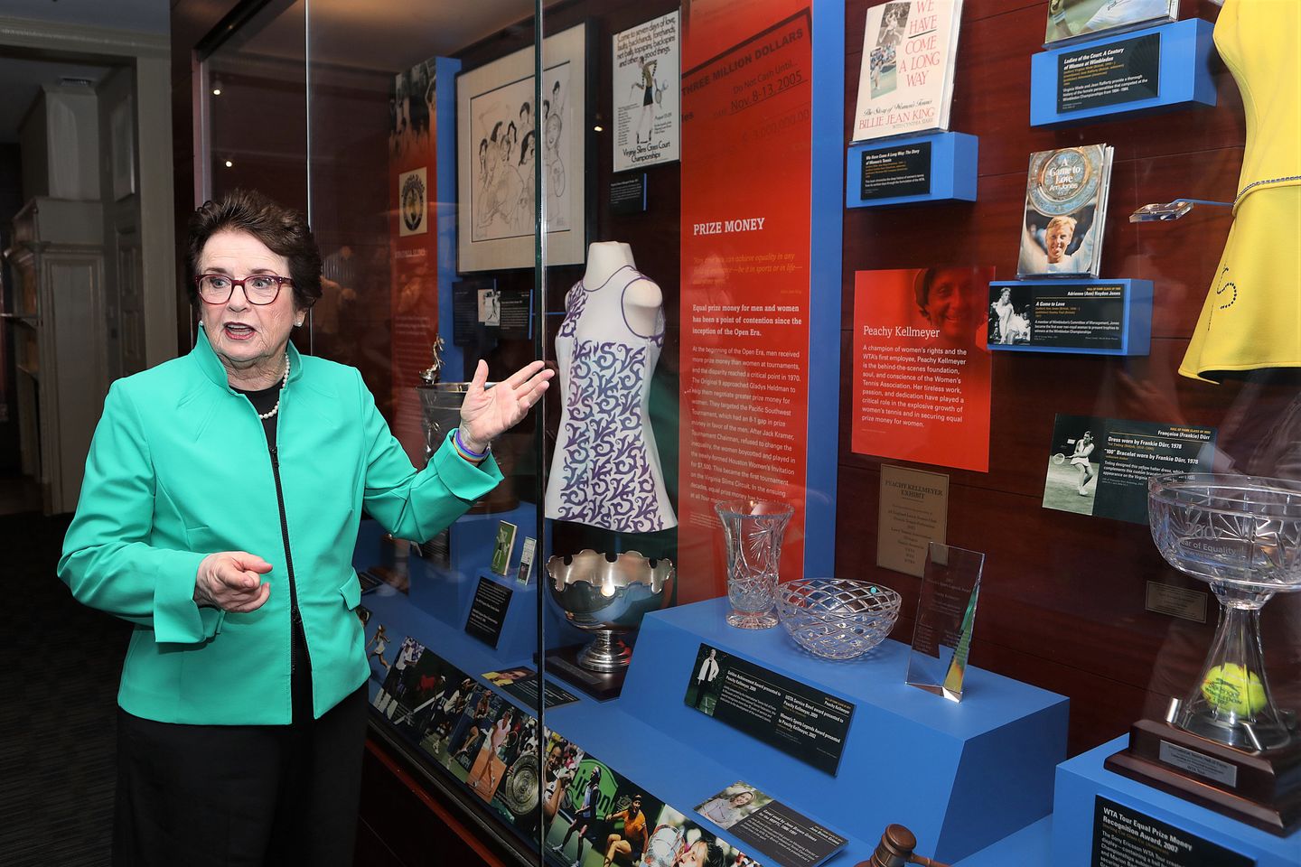 Billie Jean King paused by a cabinet display that included a dress worn by Rosie Casals on the Virginia Slims Circuit.